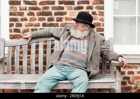 Il personaggio locale John Callaby nella foto si trova al di fuori dell'Alford Manor House nell'Alford Lincolnshire. John è ben noto ad Alford e si trova spesso fuori dalla Manor House e su panchine nel centro della città. E' ben noto per la sua caratteristica barba, cappello e pipa. E' piu' che felice di posare per fotografie ed e' parte della comunita' locale. Foto Stock