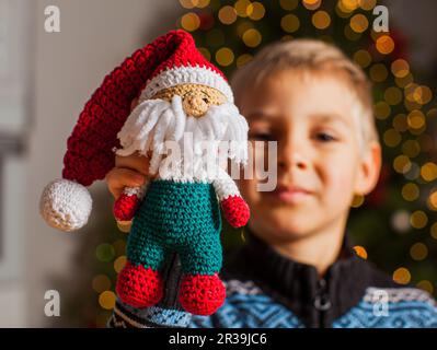 Il ragazzino che dimostra il suo giocattolo preferito di Natale Foto Stock