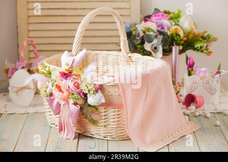 Cesto in vimini decorato con fiori e lacci Foto Stock