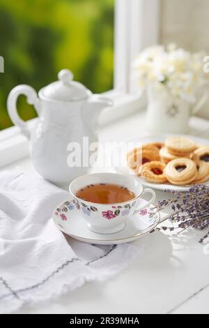 Una tazza di tè alla lavanda con biscotti assortiti Foto Stock