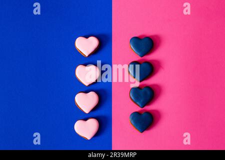 Biscotti a forma di cuore per San Valentino su sfondo a colori Foto Stock