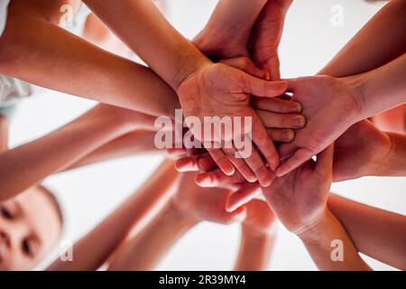 Amici felici mettendo le mani insieme, vista dal basso. Foto Stock