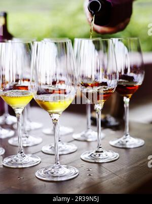 Vino che viene versato in bicchieri Foto Stock