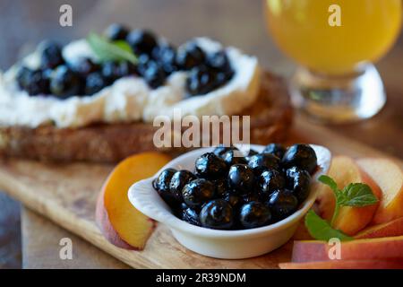 Una fetta di pane ricoperta di ricotta e mirtilli Foto Stock