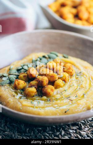 Crema di zucca alle butternut con ceci piccanti e semi di zucca Foto Stock