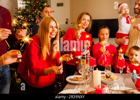 La gente felice che sorride tenendo scintilla alla vigilia di Capodanno Foto Stock