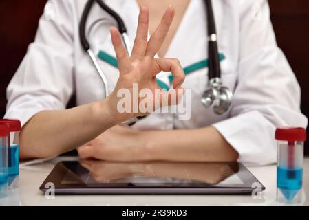 Medico donna che mostra il simbolo di successo. Primo piano Foto Stock