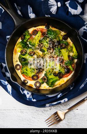 Una pizza Socca con verdure in padella di ghisa Foto Stock