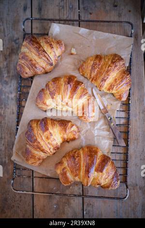 Croissant appena sfornati su sfondo rustico Foto Stock