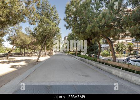 Vista su un parco urbano con alberi, pista da jogging sulla Calle 30 di Madrid Foto Stock