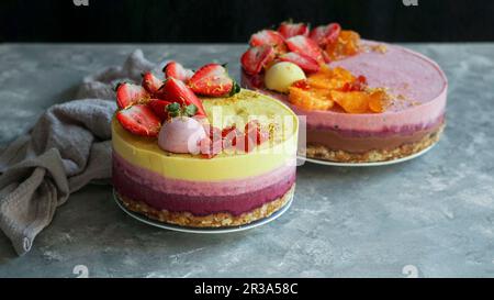 Torta di anacardi crudi vegani con bacche, burro di cocco e latte di cocco, e base di mandorle e datteri Foto Stock