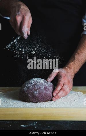 Pagnotta viola di farro aronia polvere di pane spolverato con farina Foto Stock