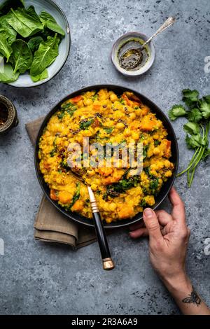 lenticchie rosse vegane, ceci e zucca dahl con spinaci in un recipiente (India) Foto Stock