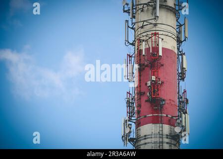 Camino rosso e bianco dell'impianto di riscaldamento che funge da palo dell'antenna con spazio di copia Foto Stock