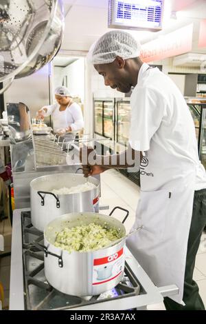 Lo staff dello chef maschile africano lavora nella cucina della sezione macelleria e deli presso il negozio di alimentari Pick n Pay locale Foto Stock