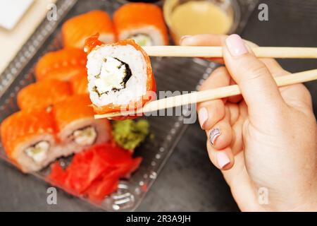 Sushi roll philadelphia. Rotolo Philadelphia in contenitore per alimenti di plastica monouso. Pranzo di lavoro conc Foto Stock