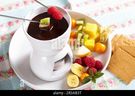 Una piccola fonduta di cioccolato per dessert con frutta fresca e biscotti Foto Stock