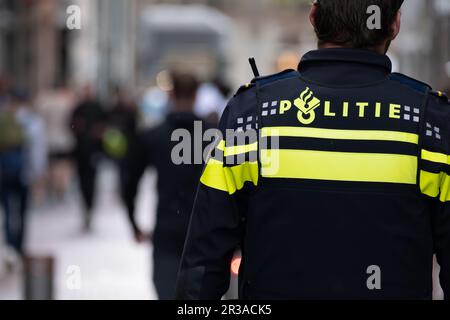 Amsterdam, Paesi Bassi - 8 settembre 2022: Il backview di un poliziotto olandese sulla strada Foto Stock