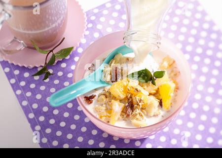 Muesli con avena, ananas, mela, arance, persimmon e latte Foto Stock