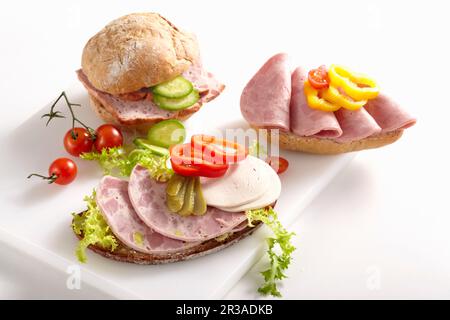 Salsiccia affettato su panini con verdure Foto Stock