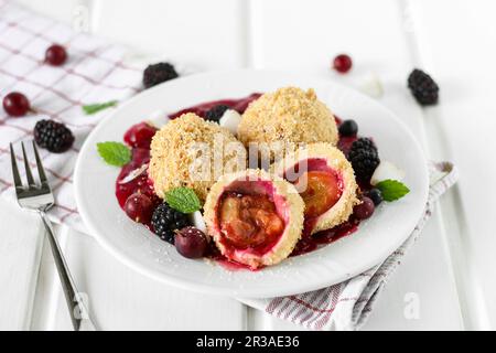 Gnocchi di Damson in una piscina di salsa di frutti di bosco Foto Stock