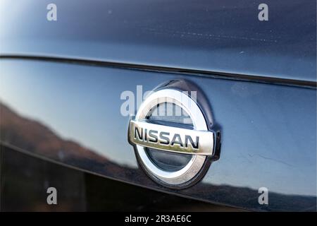 Logo Nissan auto montato sul retro di un crossover con messa a fuoco selettiva Foto Stock