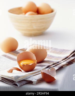 Una vita ferma con uova di pollo marroni, intere e aperte Foto Stock