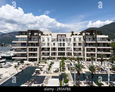 Hotel moderno con terrazze vicino alle piscine e alle spiagge sullo sfondo delle montagne. Porto, Montenegro Foto Stock