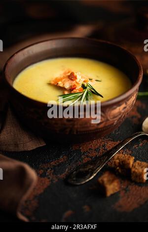 Zuppa di crema di pesce con salmone, formaggio, patate ed erbe aromatiche in zuppa di ceramica marrone. Foto cibo scuro Foto Stock