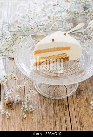 Una fetta di torta a strati su un supporto per torte Foto Stock