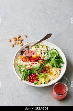 Un recipiente per insalata con couscous, verdure e condimento fruttato Foto Stock