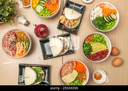 Una serie di diverse ciotole di pesce, tofu, verdure, pane bao e condimenti Foto Stock