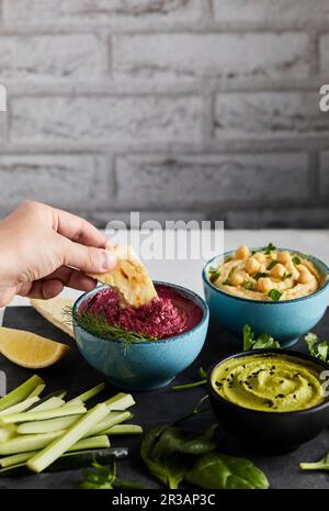 Immergere il pane pita nell'hummus delle barbabietole Foto Stock