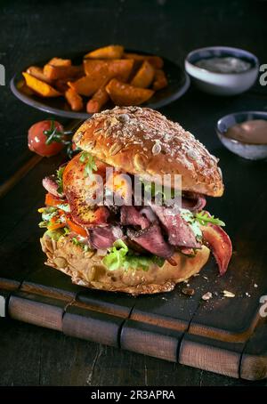 Un hamburger con arrosto di manzo, aragosta e patate spicchi Foto Stock