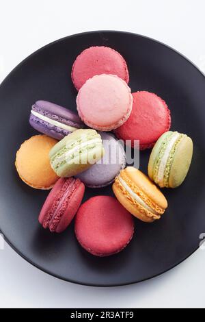 Macaron su un piatto nero Foto Stock