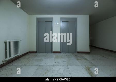 Due ascensori su un piano di un edificio residenziale con pavimenti in marmo lucido Foto Stock