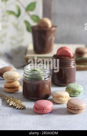 Mousse al cioccolato in bicchieri con macaron Foto Stock