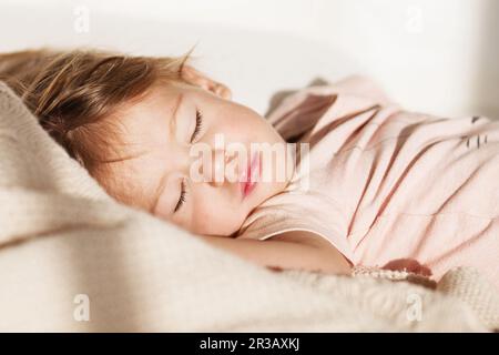 Bambina addormentata. Sonno spensierato bambino piccolo con un giocattolo morbido sul letto. Primo piano di un ritratto Foto Stock