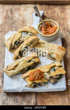 Pizza Stromboli con funghi, spinaci e mozzarella, con salsa di pomodoro Foto Stock