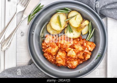 BACCALA alla livornese - merluzzo arrosto al forno in salsa di pomodoro con patate Foto Stock