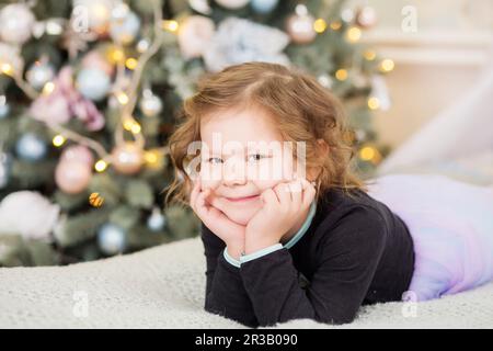 Ritratto di bella bambina in attesa di un miracolo in Decorazioni natalizie Foto Stock