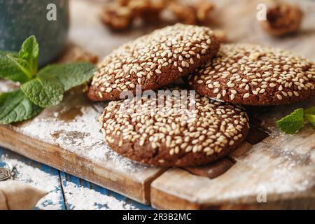 Biscotti al cioccolato con semi di sesamo sulla tavola di legno. Mystic Light fotografia alimentare. Foto Stock