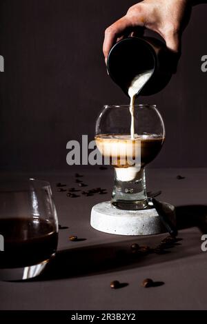 Una bevanda a base di caffè in un bicchiere con latte Foto Stock