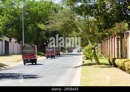 Piccolo TukTuk Grocery Store Home veicoli di consegna in auto attraverso la periferia Foto Stock