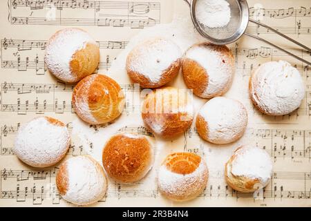 Profiteroles fatti in casa sul spartiti con note. Profiteroles (choux Ã la crÃ¨me) - choux francese Foto Stock