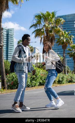 Studenti felici che si divertono insieme in piedi nel parco durante le giornate di sole Foto Stock