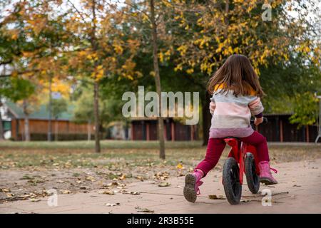 Ragazza in bicicletta sul sentiero al parco Foto Stock