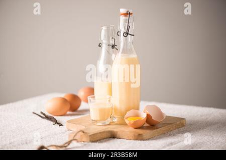 Eggnog in bottiglie e un bicchiere Foto Stock