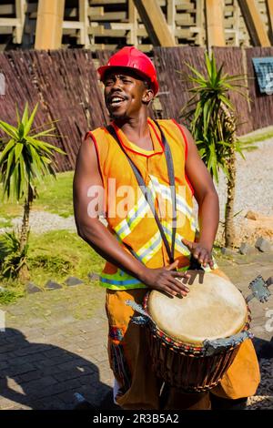 Uomini africani che suonano tamburi tradizionali per i turisti della borgata di Soweto Foto Stock