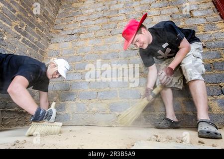 Programma di attività di comunità diversificata che aiuta a costruire una piccola casa a prezzi accessibili in una cittadina locale Foto Stock